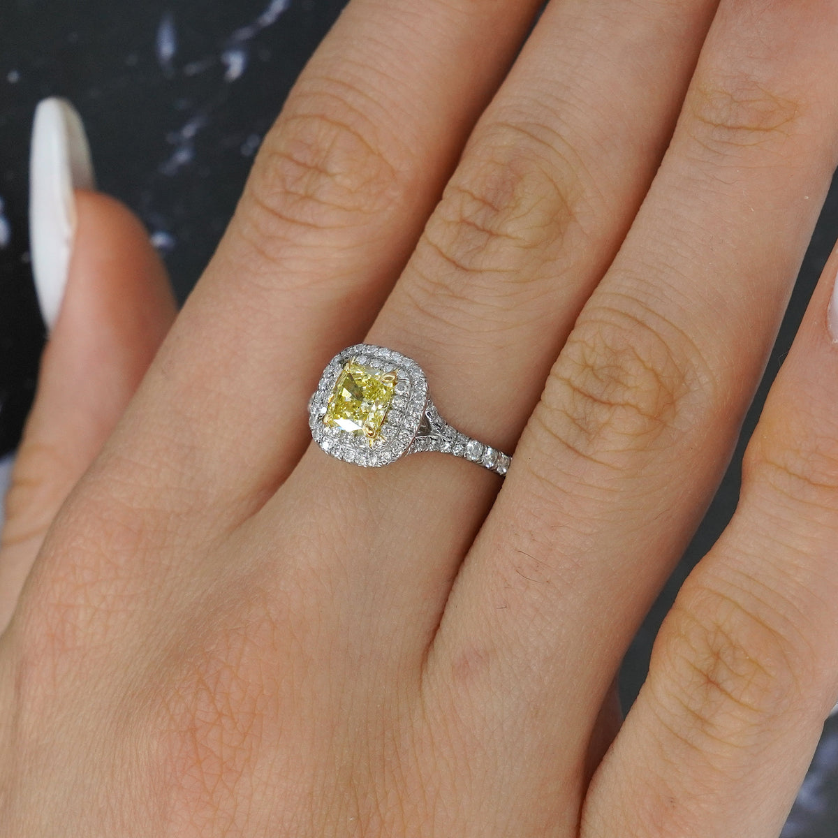 Tiffany and Co Soleste diamond and platinum ring with a 0.78 ct Fancy Intense yellow cushion cut diamond, front view of ring on a models hand.